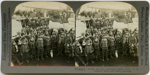 Horizontale, sepia stereokaart met Amerikaanse soldaten in uniform met reddingsvesten op het dek van een schip. Keystone Stereograph nummer V19217. De titel luidt door Keystone View Company